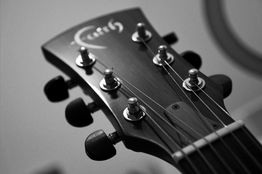 Detailaufnahme einer Akustikgitarre – Saiten und Mechaniken im Fokus. Livemusik in Augsburg und Umgebung.